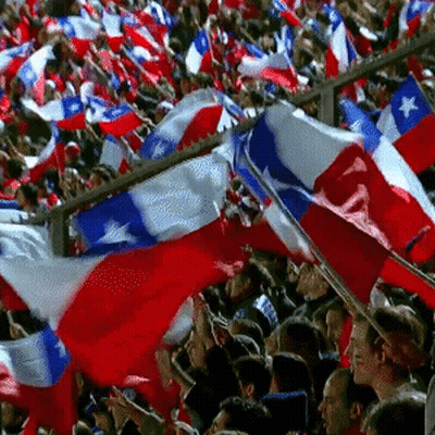 A Crowd Of People Are Waving Red White And Blue Flags In A Stadium GIF
