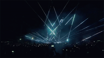 A Crowd Of People At A Concert With Smoke Coming Out Of The Ceiling GIF