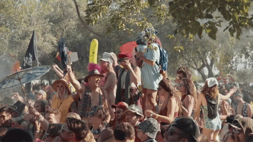 A Crowd Of People At A Festival With A Flag That Says Pirate GIF