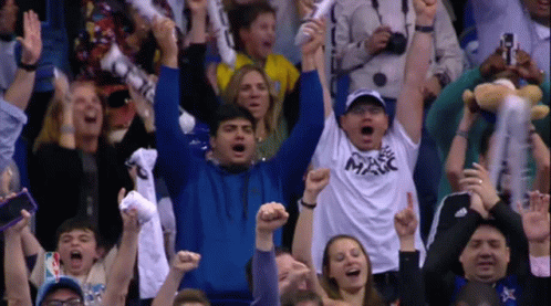 A Crowd Of People In A Stadium Including A Man Wearing A Shirt That Says Magic GIF
