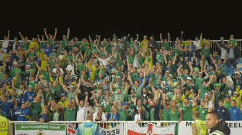 A Crowd Of People In A Stadium With A Banner That Says Newtownards Gawa GIF