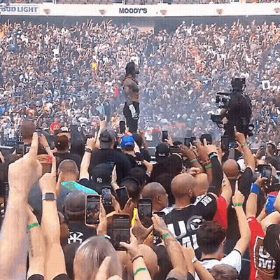 A Crowd Of People In A Stadium With A Bud Light Sign Above Them GIF