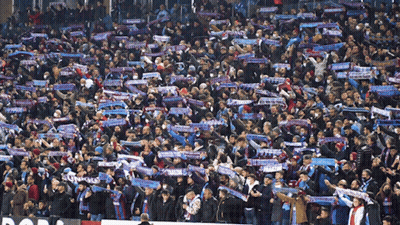 A Crowd Of People In A Stadium With A Scarf That Says ' Tivoli ' On It GIF