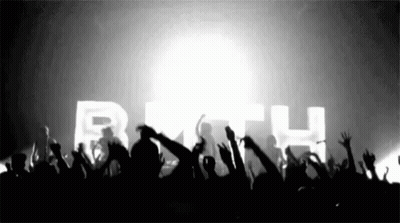 A Crowd Of People Raising Their Hands In The Air In Front Of A Sign That Says Beth GIF