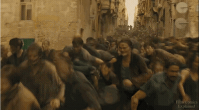 A Crowd Of People Running Down A Street With A Sign That Says Film Comics Explained On It GIF