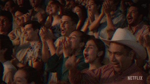 A Crowd Of People Sitting In A Stadium Applauding With Netflix Written In The Corner GIF