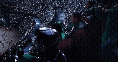 A Crowd Of People Sitting In A Stadium Watching A Game . GIF
