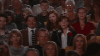 A Crowd Of People Sitting In A Stadium Watching A Presentation GIF
