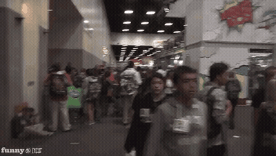 A Crowd Of People Walking In A Hallway With The Words Funny On The Bottom Right GIF