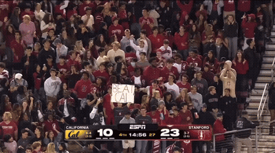 A Crowd Of People Watching A Basketball Game With A Sign That Says Beat Cal GIF