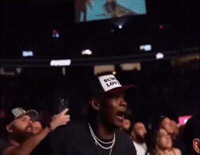 A Crowd Of People Watching A Boxing Match With One Man Wearing A Shirt That Says Kings GIF