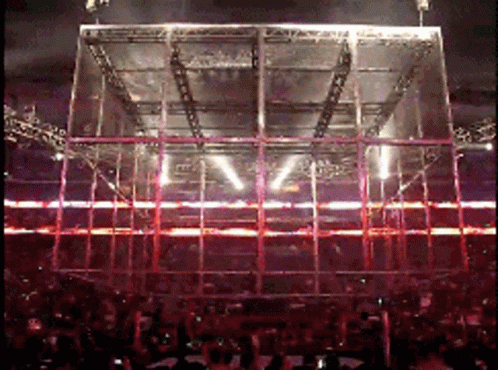 A Crowd Of People Watching A Concert With A Large Stage In The Middle GIF