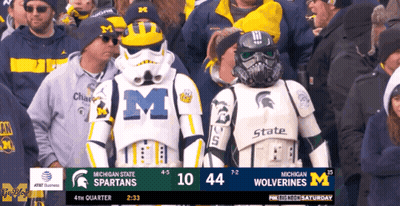 A Crowd Of People Watching A Game Between Michigan State Spartans And Wolverines GIF