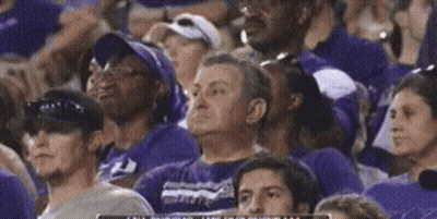 A Crowd Of People Wearing Purple Shirts Are Watching A Game GIF