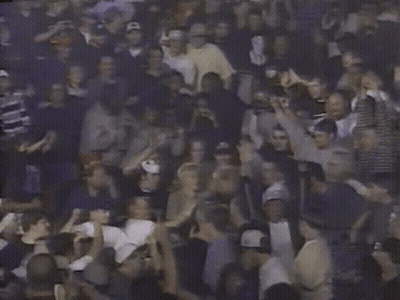 A Crowd Of People With Their Hands In The Air Including A Man Holding A Sign That Says ' A ' GIF