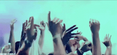 A Crowd Of People With Their Hands In The Air . GIF