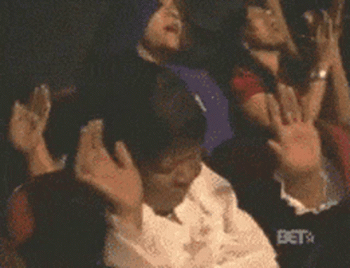 A Crowd Of People With Their Hands In The Air With Bet On The Bottom GIF