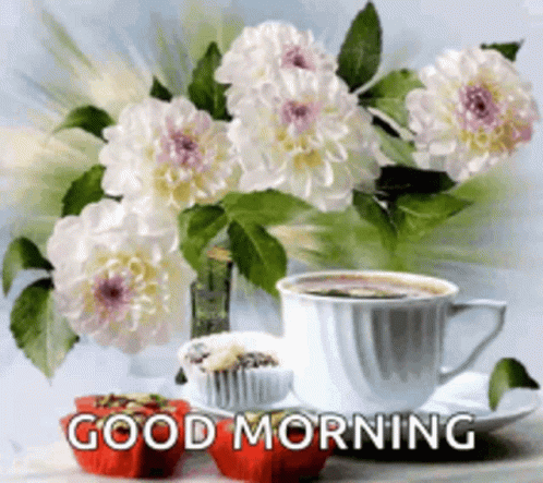 A Cup Of Coffee And Cupcakes Are On A Table Next To A Vase Of Flowers . GIF