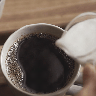A Cup Of Coffee Is Being Poured Into Another Cup GIF
