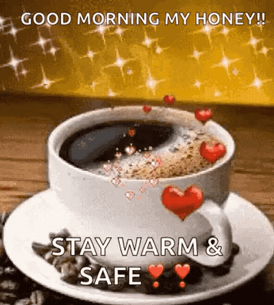 A Cup Of Coffee With Hearts On It Is On A Saucer On A Table . GIF