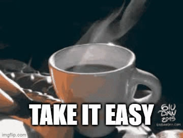 A Cup Of Coffee With Steam Coming Out Of It Is Sitting On A Table . GIF