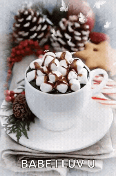A Cup Of Hot Chocolate With Marshmallows On Top Is On A Saucer . GIF