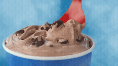 A Cup Of Ice Cream With A Red Spoon In It GIF