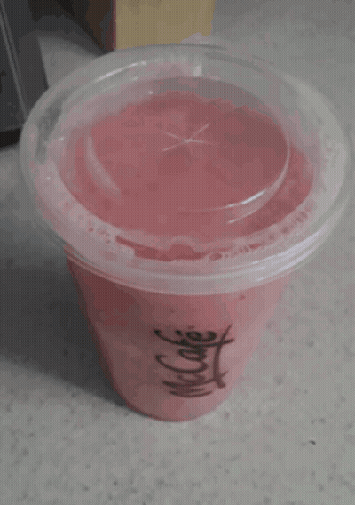 A Cup Of Pink Liquid With A Clear Lid And A Chinese Symbol On It GIF