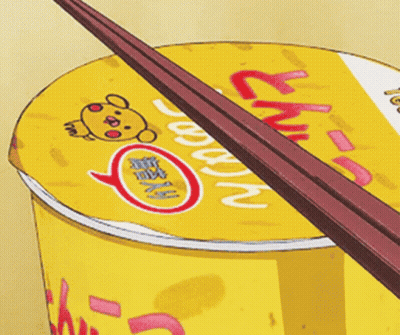 A Cup Of Ramen With Chopsticks Sticking Out Of The Top GIF