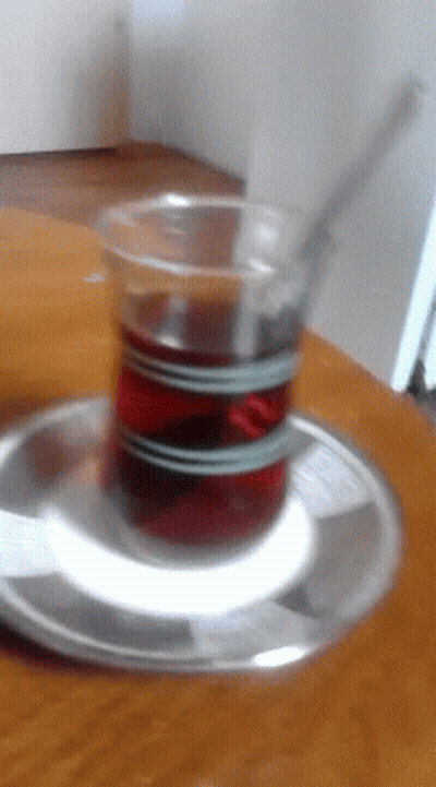 A Cup Of Tea Is On A Saucer On A Table GIF