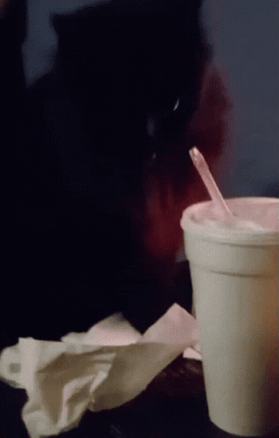 A Cup With A Straw In It Sits On A Table GIF