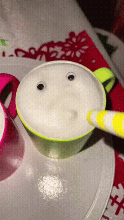 A Cup With Googly Eyes And A Yellow And White Striped Pen GIF