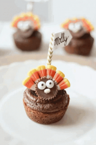 A Cupcake With A Peanut Butter Cup In The Shape Of A Turkey And A Name Tag That Says Molly GIF