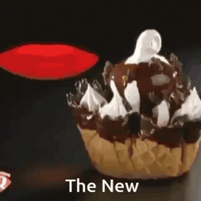 A Cupcake With Chocolate Sauce And Whipped Cream With The Words The New Above It GIF
