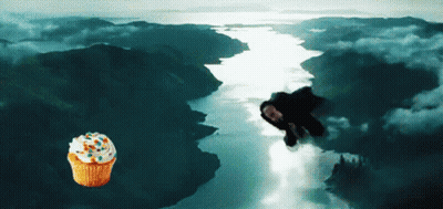 A Cupcake With Sprinkles Is Flying Over A River GIF