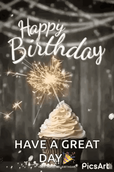 A Cupcake With Whipped Cream And A Sparkler On Top Of It . GIF