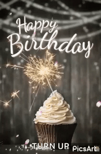 A Cupcake With Whipped Cream And A Sparkler On Top . GIF