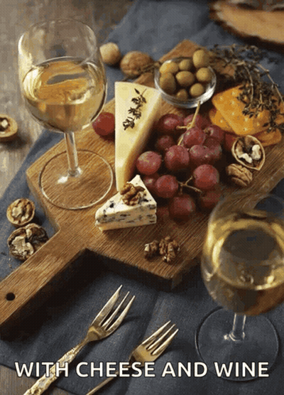 A Cutting Board With Cheese Grapes And Wine With The Words With Cheese And Wine Below GIF