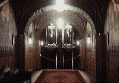 A Dark Hallway With A Red Carpet And Two Displays GIF