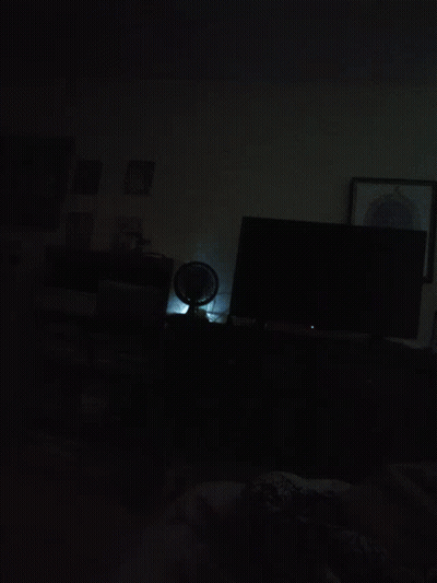 A Dark Room With A Picture On The Wall GIF