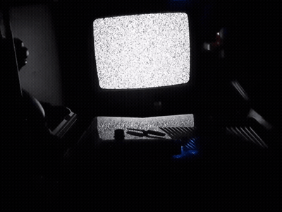 A Dark Room With A Tv That Has A Lot Of Static GIF