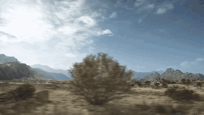 A Desert Landscape With Mountains In The Background And Trees In The Foreground GIF