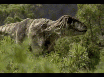 A Dinosaur Is Walking Through A Field Of Grass GIF