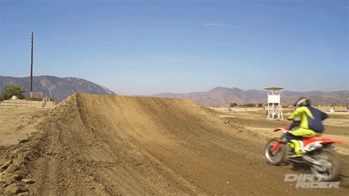 A Dirt Rider Is Riding A Dirt Bike On A Track GIF