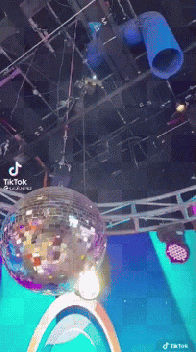 A Disco Ball Is Hanging From The Ceiling Of A Room . GIF