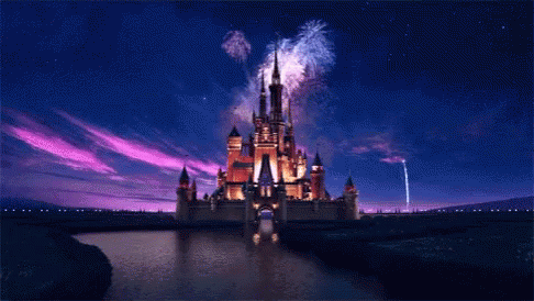 A Disney Castle Is Lit Up At Night With Fireworks GIF