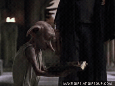 A Dobby From Harry Potter Is Kneeling Down Next To A Man In A Suit . GIF