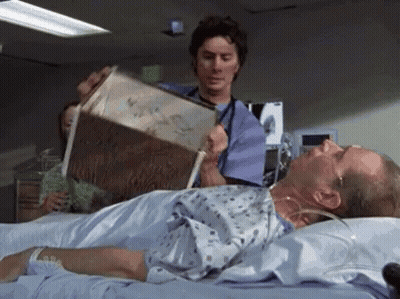 A Doctor Is Reading A Book To A Patient In A Hospital Bed . GIF