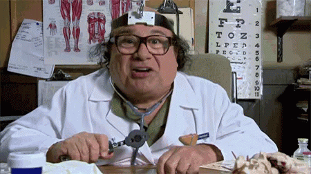 A Doctor Wearing Glasses And A Stethoscope Is Sitting At A Desk GIF