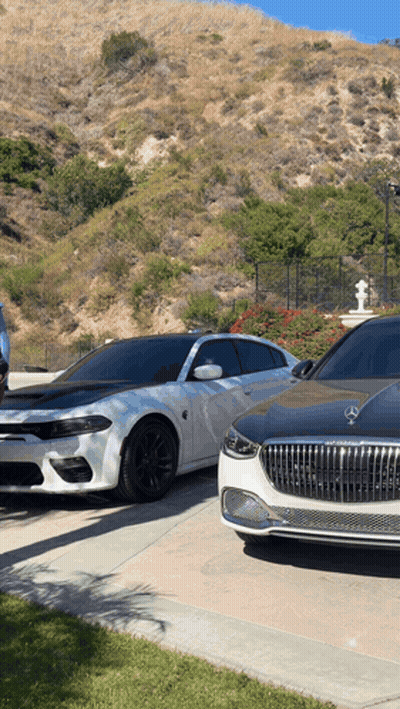 A Dodge Charger Is Parked Next To A Mercedes GIF
